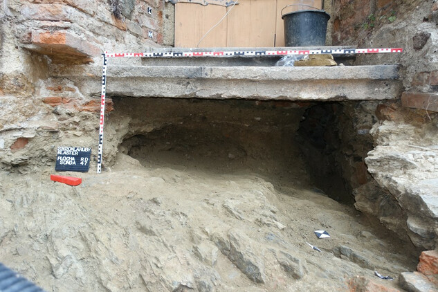 Povrch skály s hrobovou jámou po vyjmutí kostry (vpravo).
